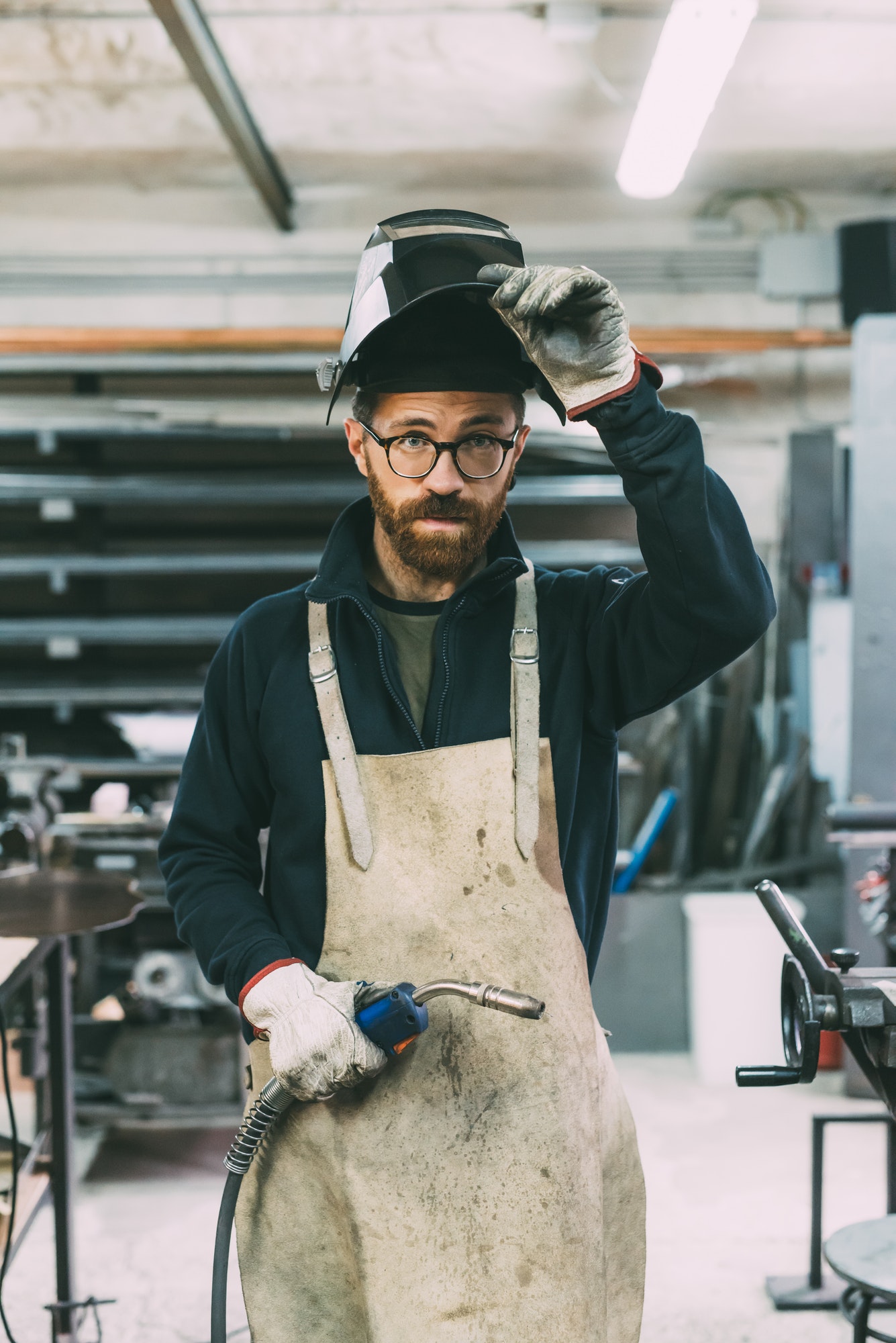 portrait-of-metalworker-holding-welding-torch-in-forge-workshop.jpg